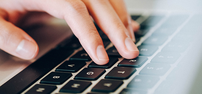 Laptop keyboard with man typing