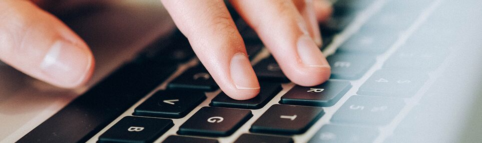 Laptop keyboard with man typing